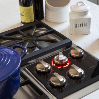 black gas stove with casserole and white jar