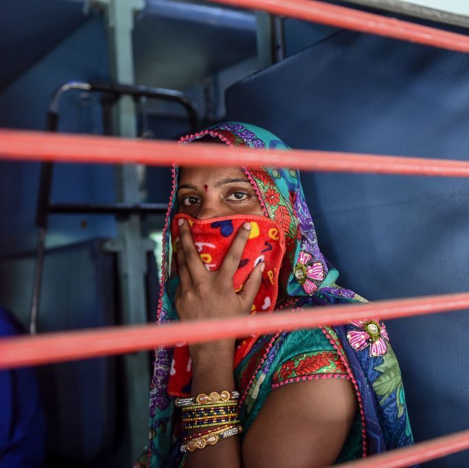a migrant worker looks out of a compartments window as she sits inside a special train going to agra in uttar pradesh state during a government imposed nationwide lockdown as a preventive measure against the covid 19 coronavirus, at sabarmati railway station on the outskirts of ahmedabad on may 2, 2020 photo by sam panthaky afp photo by sam panthakyafp via getty images