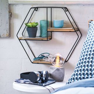 hexagonal shelf on white wall and headphones on table