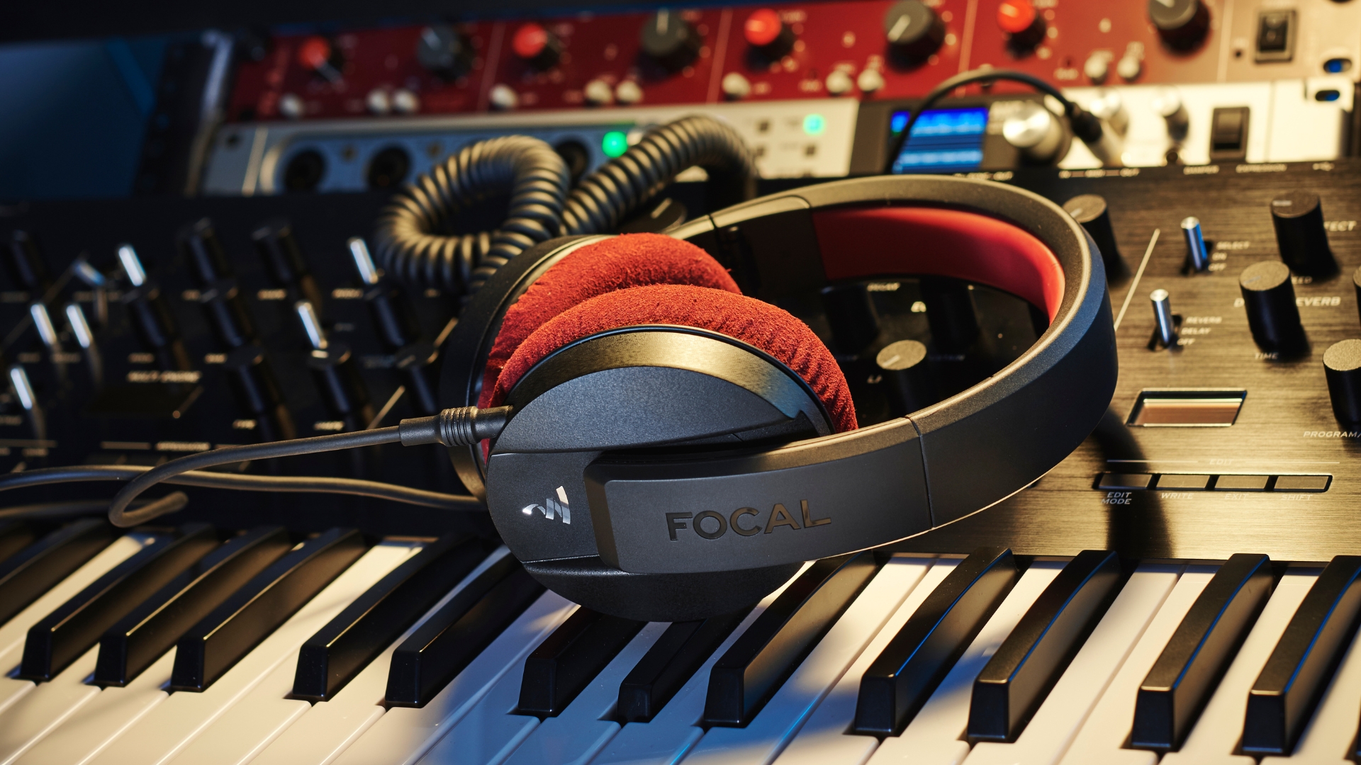 A pair of Focal headphones lying on a synthesizer