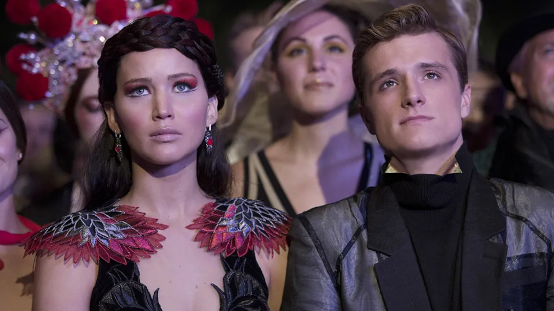 Jennifer Lawrence as Katniss Everdeen and Josh Hutcherson as Peeta Mellark standing together as a couple in The Hunger Games: Catching Fire.