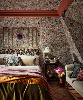 bedroom with floral, william morris wallpaper on walls and ceiling, finished with accents of red paint, maximalist bedroom decor