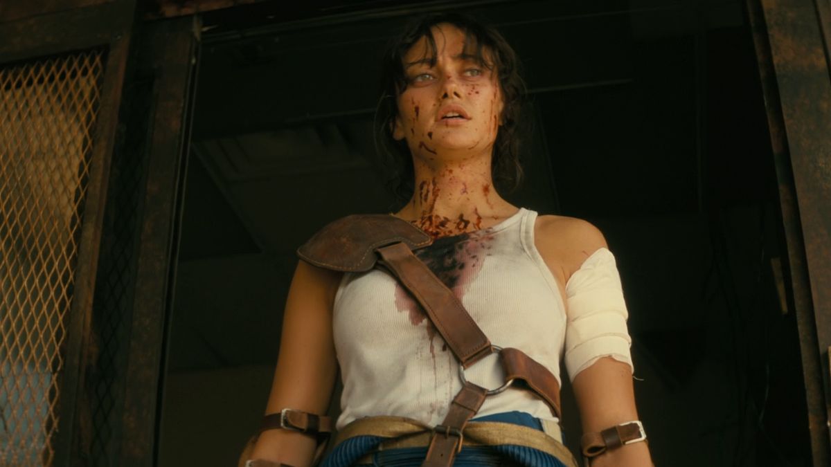 A screengrab from Fallout episode 4, showing a bloodied Lucy (Ella Purnell) sporting her new armored Vault suit look.