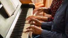 A stock photo of people playing the piano.