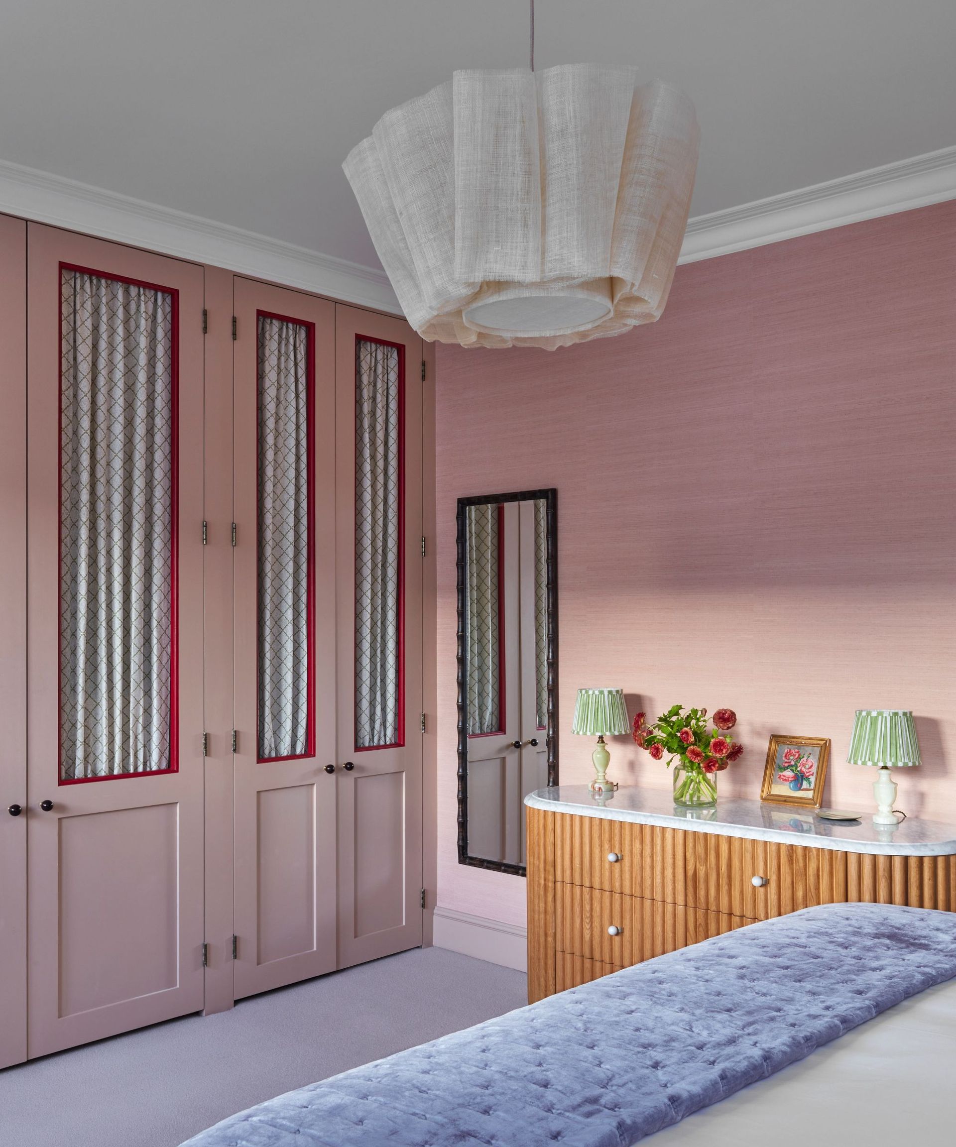 pink bedroom with pendant light and pink cabinets