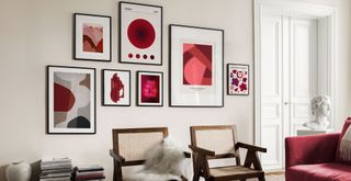 White living room with a gallery wall of black framed artwork in vivid red to supper the Pantone color of the year 2023