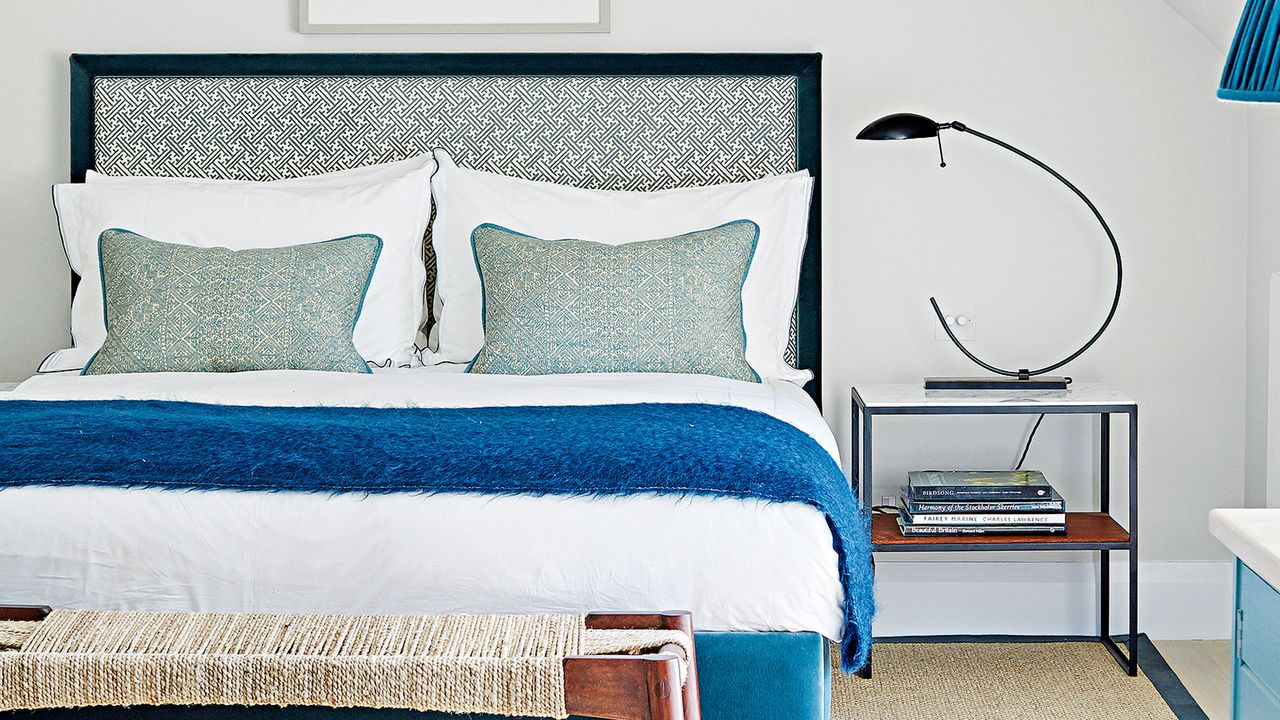 A white bedroom with blue accessories and bedding