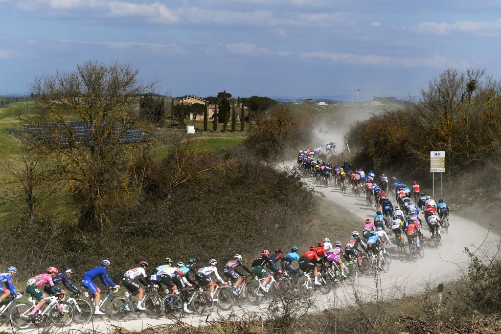 SIENA ITALY MARCH 05 The peloton passing through a gravel strokes sector during the Eroica 16th Strade Bianche 2022 Mens Elite a 184km one day race from Siena to Siena Piazza del Campo 321m StradeBianche WorldTour on March 05 2022 in Siena Italy Photo by Tim de WaeleGetty Images