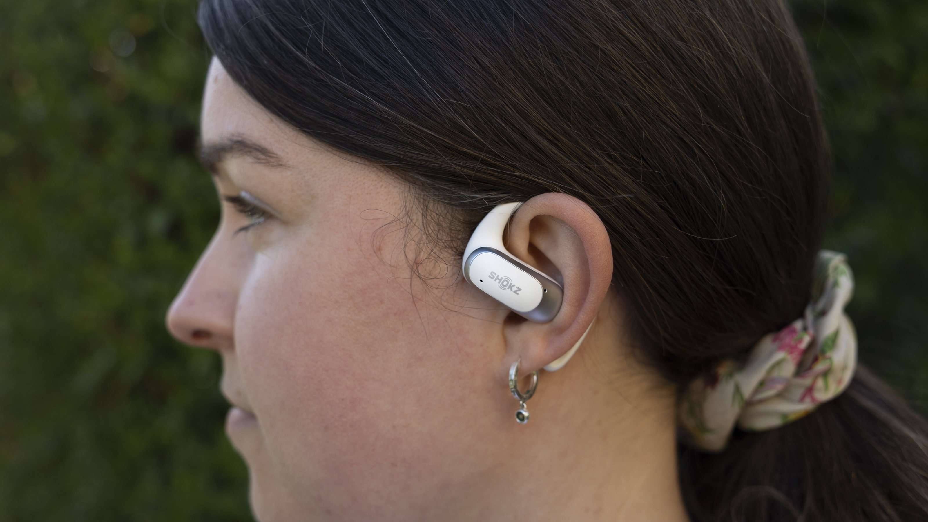 A side view of a female wearing the Shokz OpenFit Air headphones