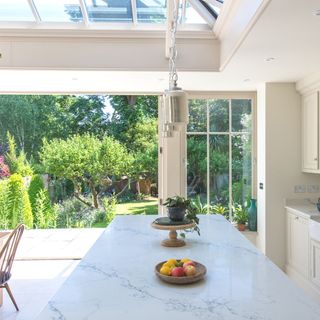 orangery used as a kitchen extension with patio doors opened to the garden
