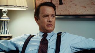 Tom Hanks reclines in his office with a face of shock in Charlie Wilson's War