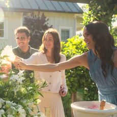 Meghan Markle toasts with a glass of champagne