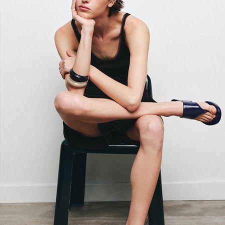 Zara model wearing black tank, bangles, and navy heels