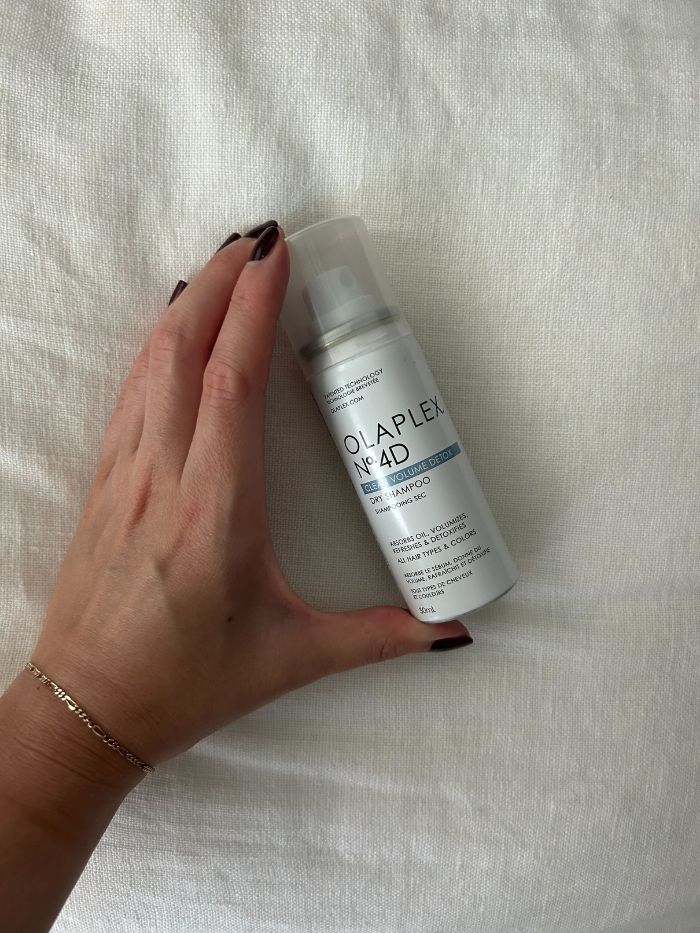 junior beauty editor grace lindsay holding an olaplex dry shampoo