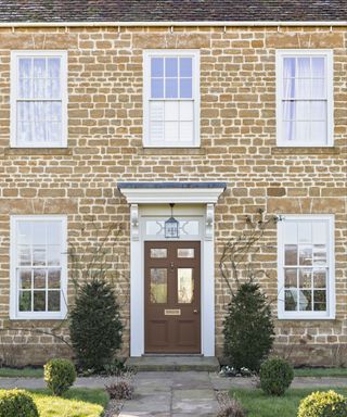 traditional home with brick exterior and brown front door