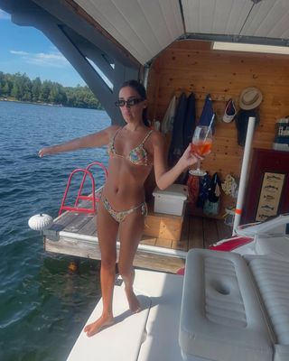 woman wearing bikini by boat on lake