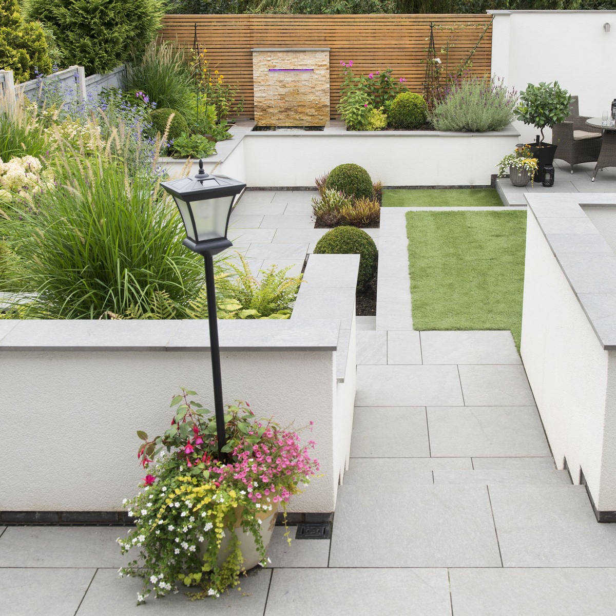 Beautiful Southern garden with colourful flowers and a water fountain