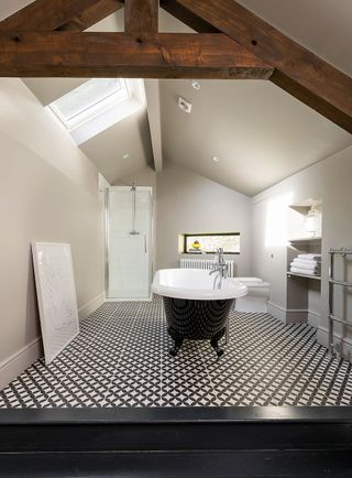 renovated bathroom with exposed beams and rolltop bath