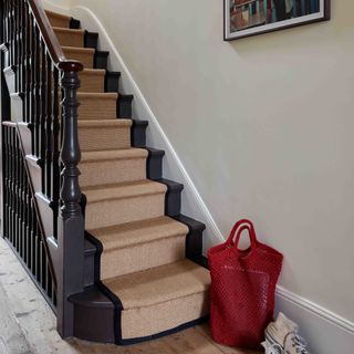 Black staircase and banister with black and brown carpet runner