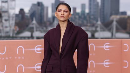 Zendaya wearing a plum suit while attending a Dune: Part Two photocall