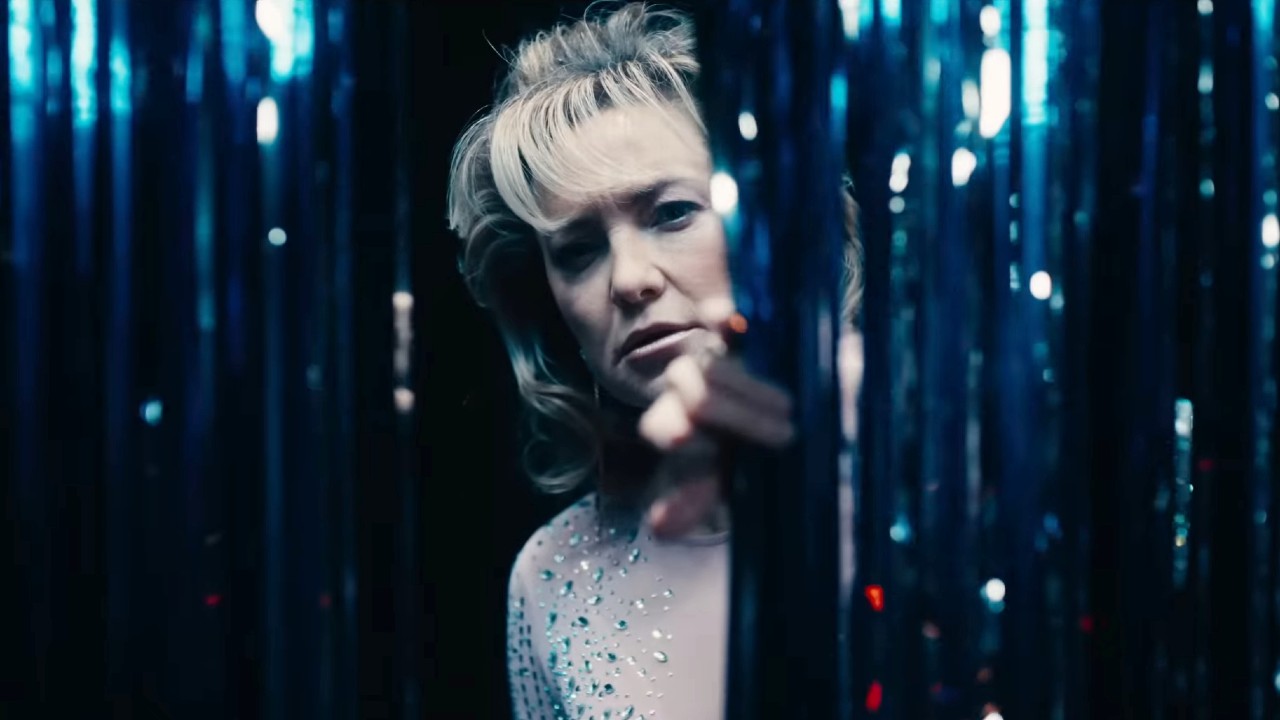 Kate Hudson looking over in Song Sung Blue.