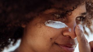 woman applying sunscreen to face