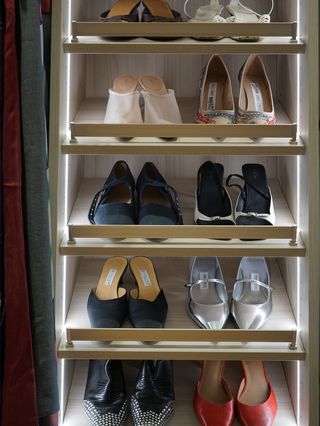 A photo of kat's shoes organized in her closet.