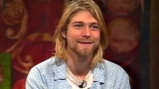 Kurt Cobain smiles as he watches footage of college students reviewing In Utero