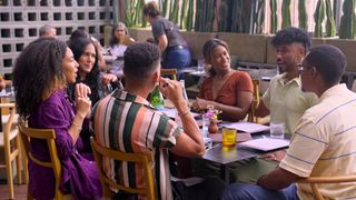 A family sits together at a restaurant patio, in 'Love is Blind' season 7.