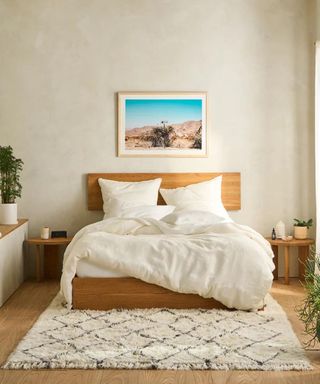 A bed with Brooklinen bedding against a white wall.