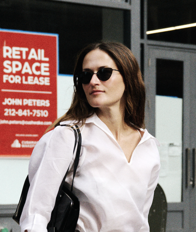 Eliza Huber wearing a white collared top and sunglasses.