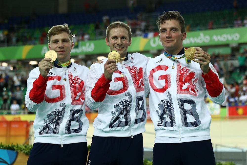 Philip Hindes, Jason Kenny and Callum Skinner of Great Britain celebrate after winning gold and getting an Olympic record in the Men's Team Sprint