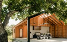 A modern outdoor kitchen under a gabled roof