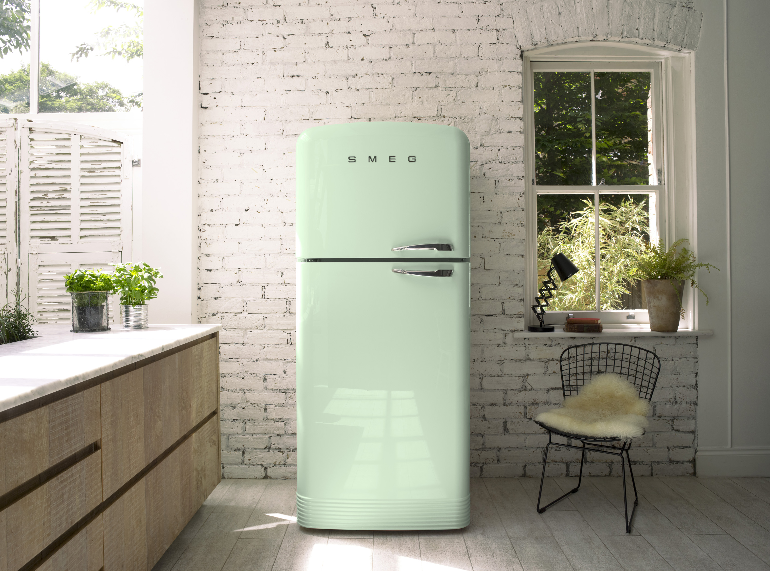 soft green fridge in a white kitchen with a white brick wall