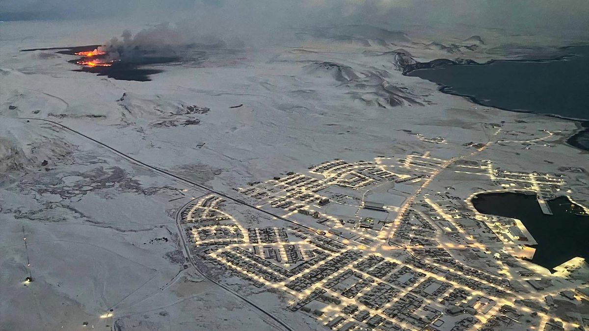 The evacuated Icelandic town of Grindavik (R) is seen as smoke billow and lava is thrown into the air from a fissure during a volcanic eruption on the Reykjanes peninsula 3 km north of Grindavik, western Iceland on December 19, 2023.