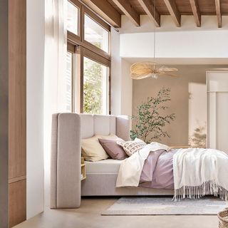 Beige bedroom with white uphostered bed with curved headboard