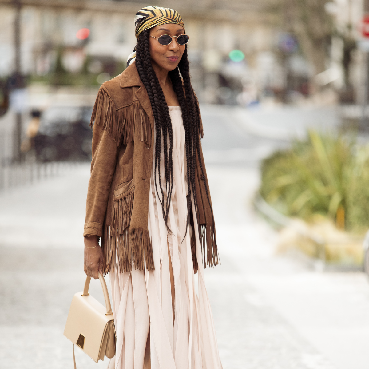 Woman wearing a brown suede jacket with a pink dress and head scarf