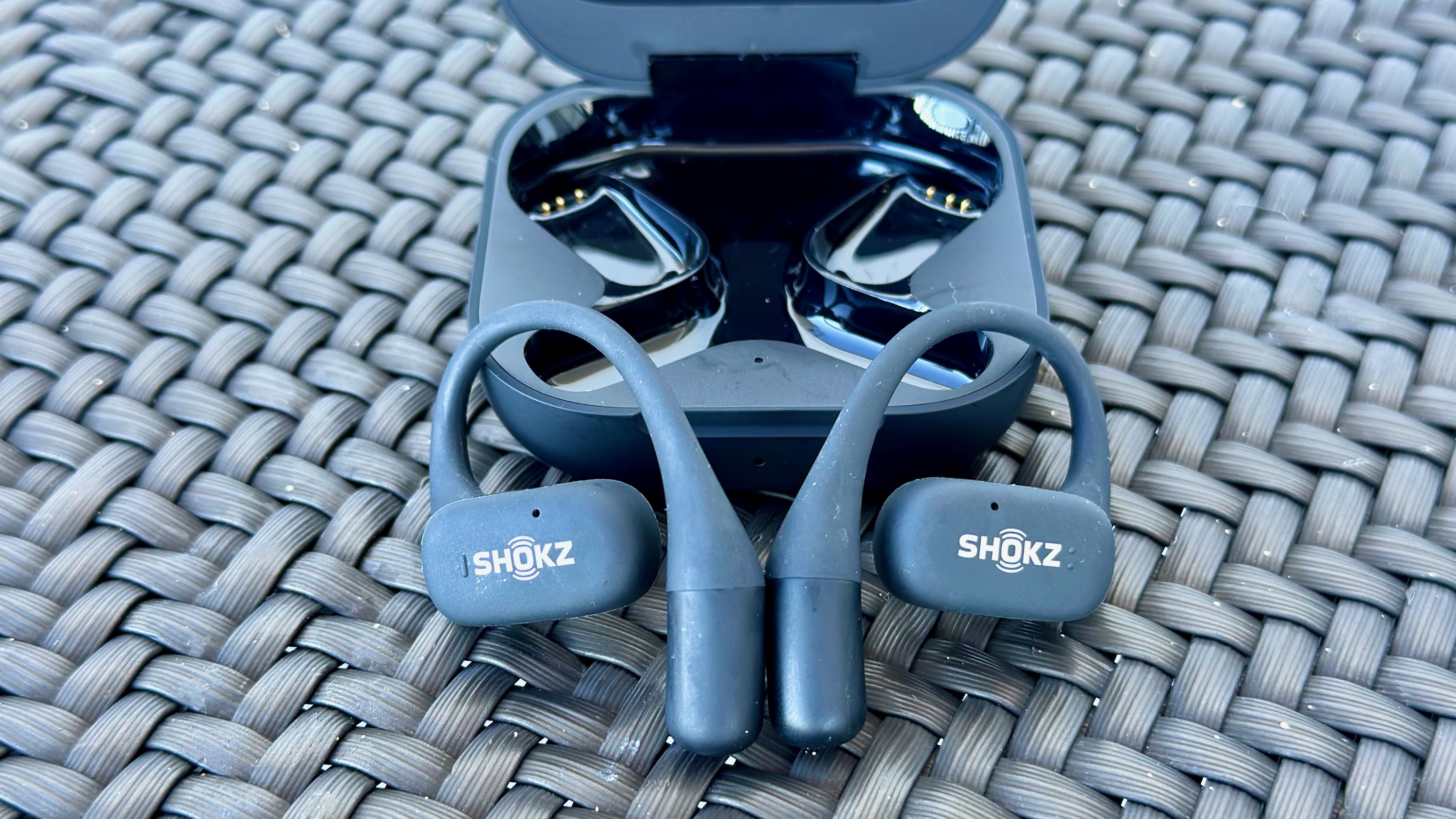 The Shokz OpenFit earbuds sitting on top of the charging case