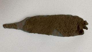 A metal dagger covered with dirt