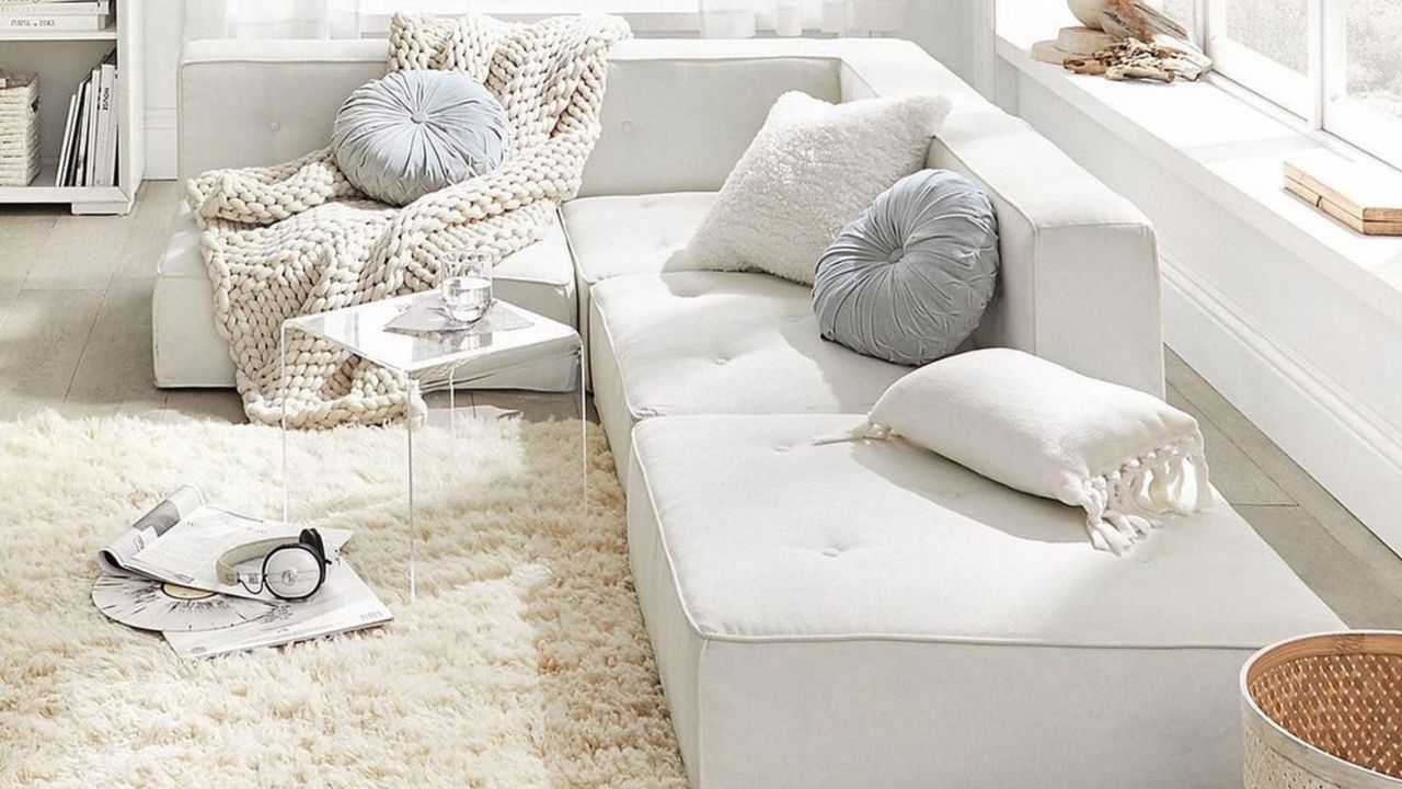 White sectional couch with chunky knit blanket