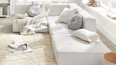 White sectional couch with chunky knit blanket