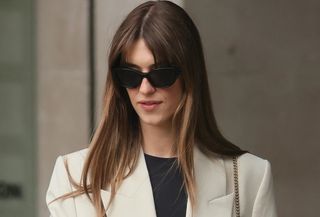 Daisy Edgar-Jones wearing a cream blazer with matching Bermuda shorts and snakeskin sandals.