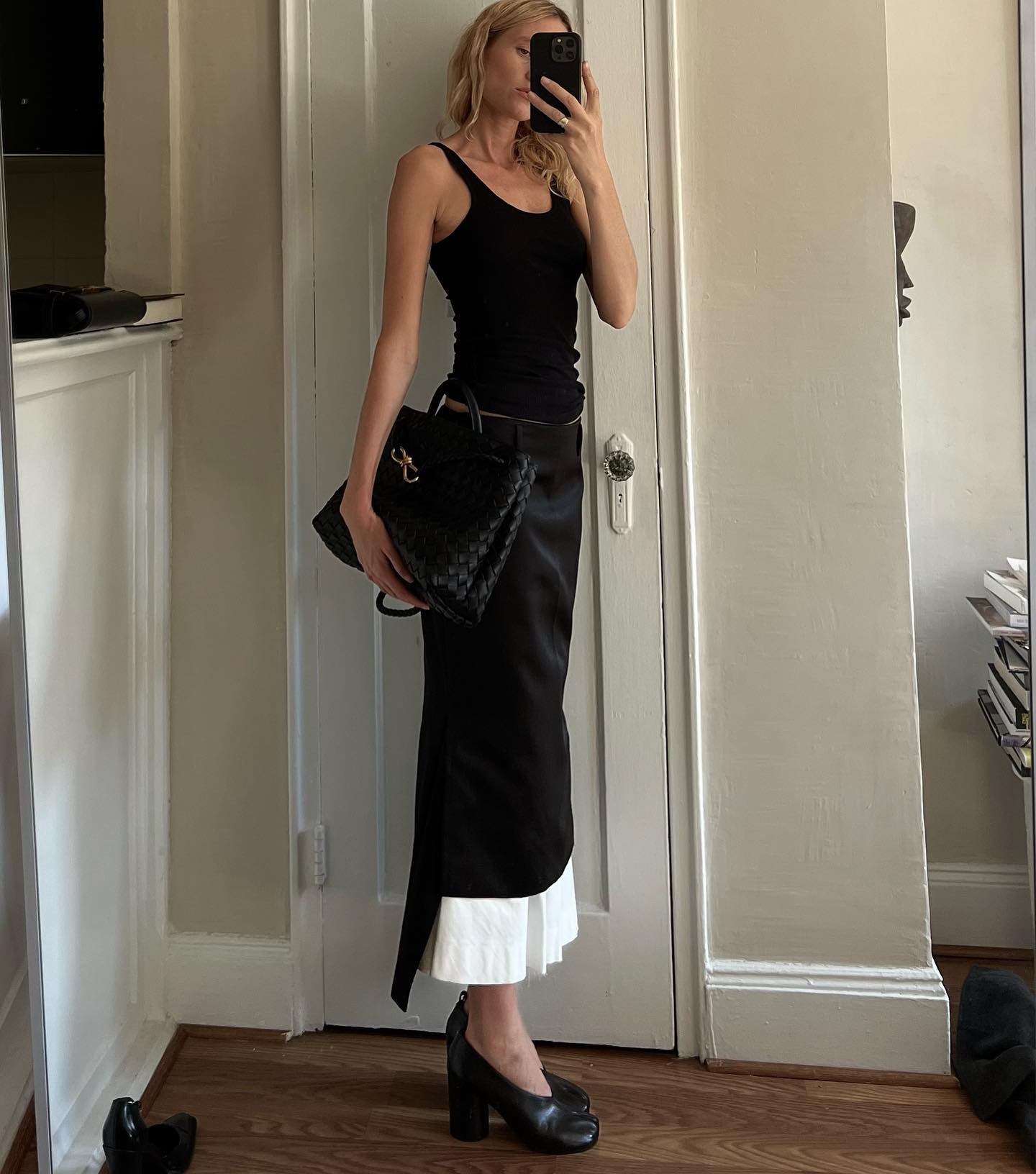Elly McGaw wearing a black tank top, black-and-white skirt, and black Bottega Veneta bag.