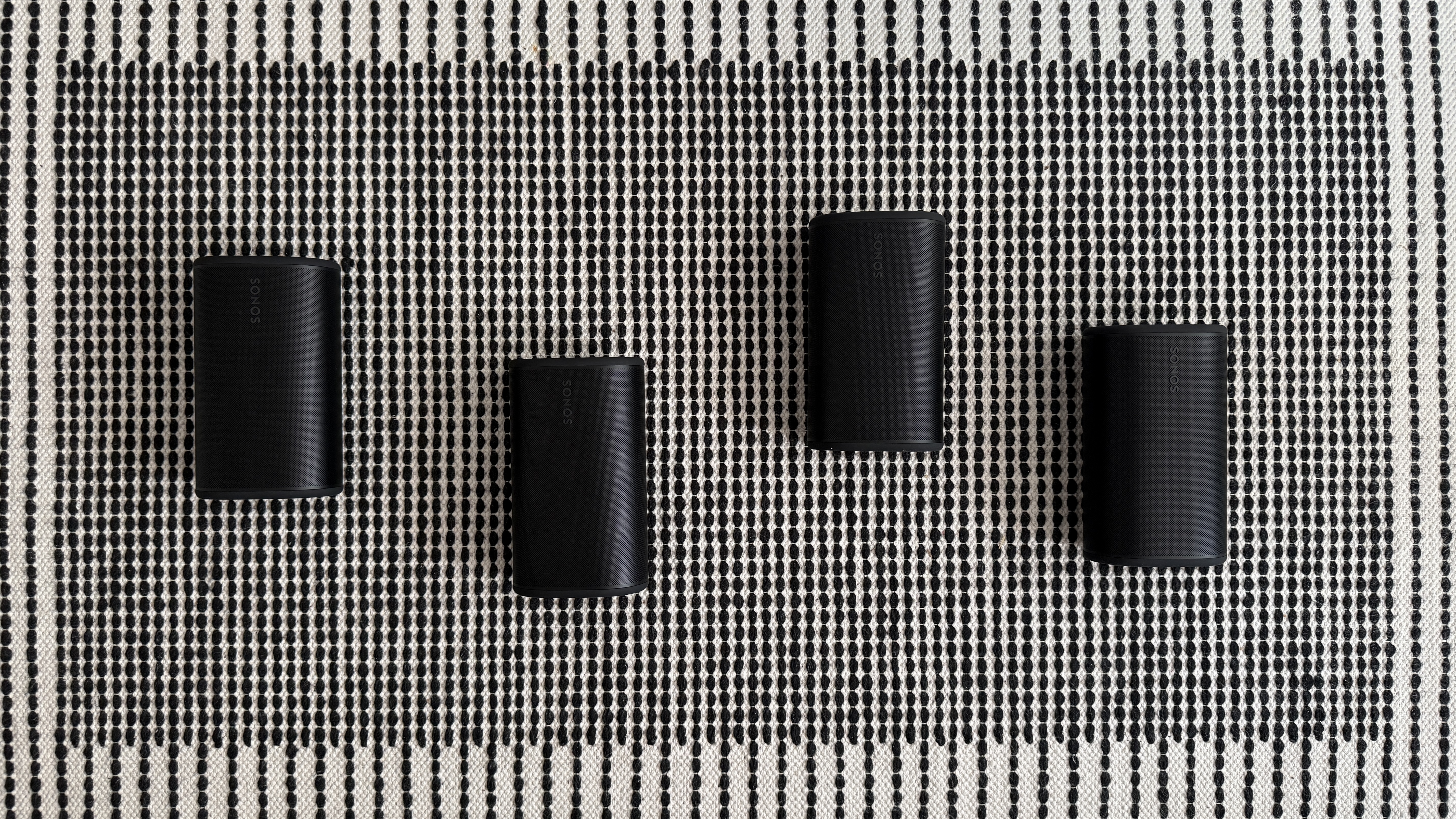 Four Sonos Play speakers on a stripey rug