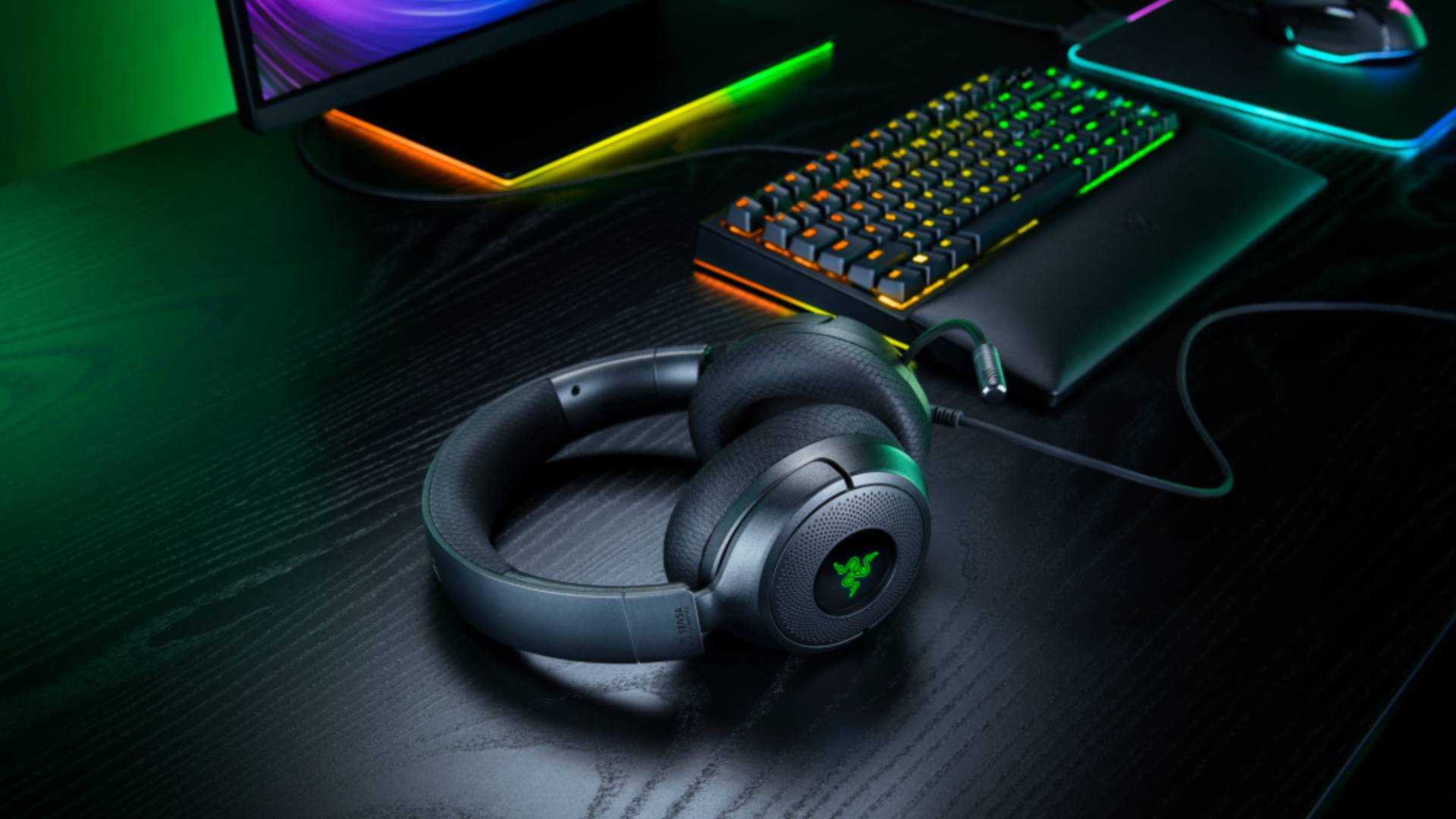 Image of the Kraken V4 X Sensa HD Haptics headset sitting on a black gaming desk.