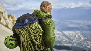 how to store climbing rope: climber with coiled rope in backpack
