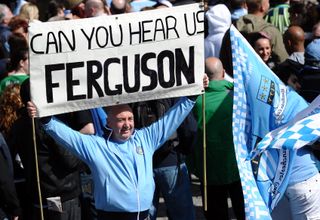 A Manchester City fan holds up a sign aimed at Manchester United manager Sir Alex Ferguson during the Sky Blues' FA Cup celebrations in May 2011.