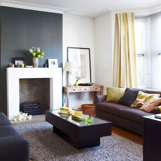 Living room with dark grey wall and yellow curtains and cushions