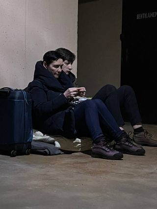Two people huddling together in Kyiv Ukraine shelter
