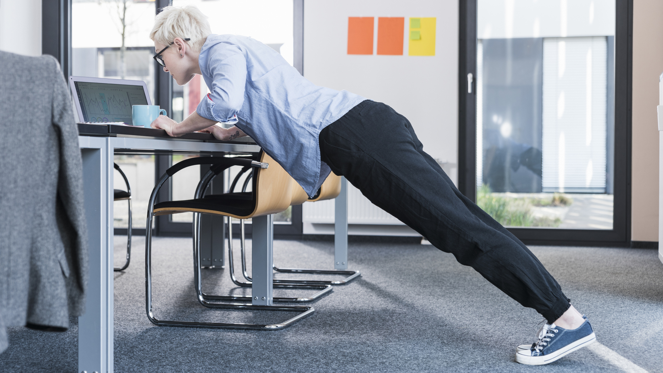 Woman in office doing incline push-ups on a desk